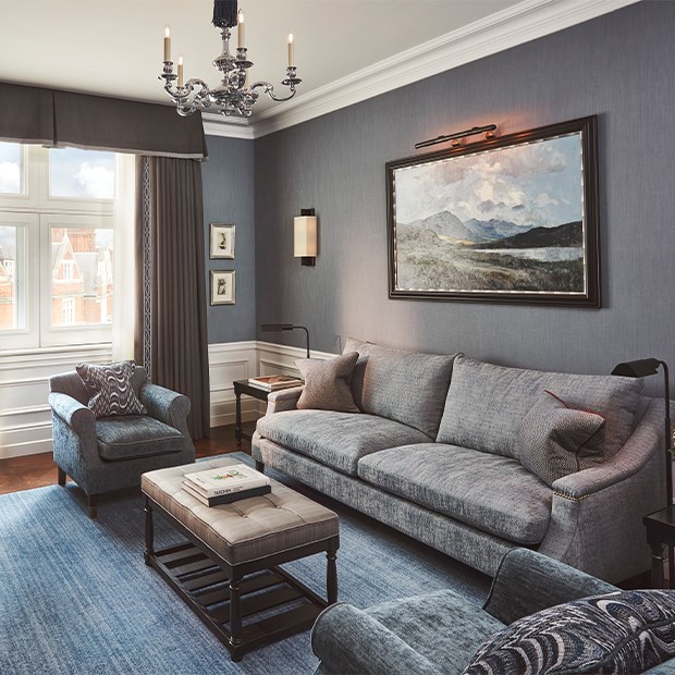 Coburg Suite: living area with sofa, coffee table, books, painting at the back of the room