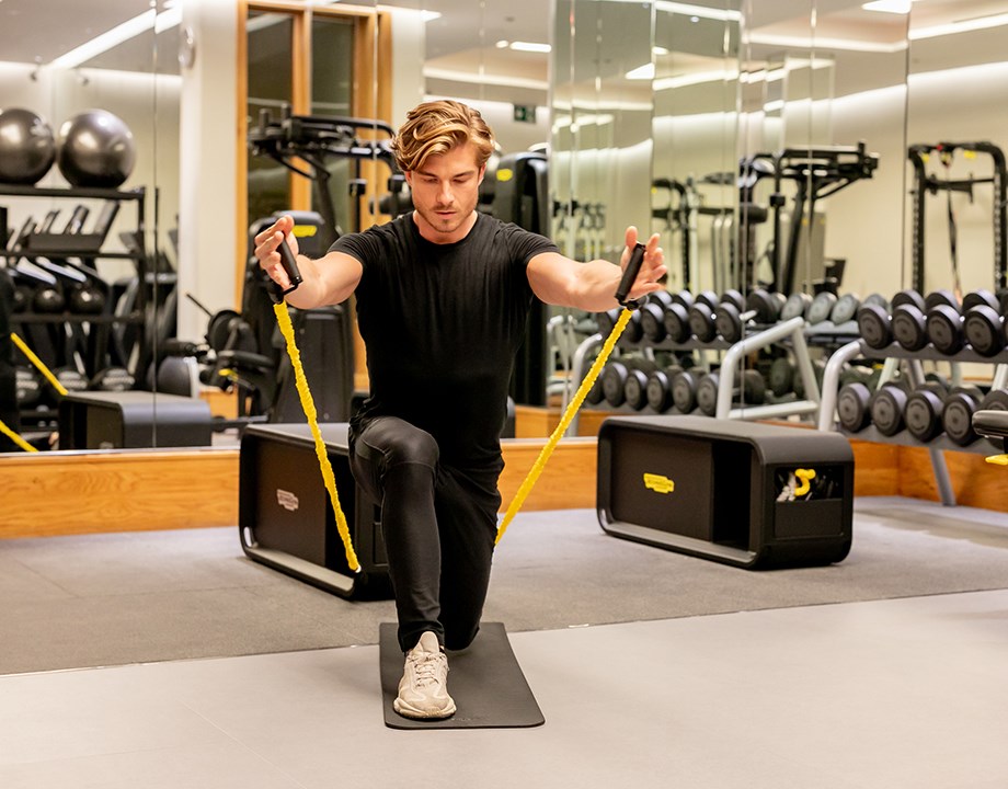 Focused man exercising with bands in The Connaught's spacious Aman Spa gym.
