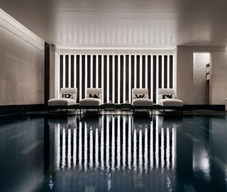 Four comfortable recliners, next to the black granite swimming pool in Aman Spa.