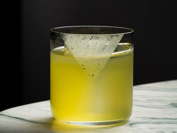 Bright yellow cocktail in short glass with ice