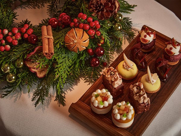 Decorated festive wreath on the left and a plate of intricate patiserrie on the right