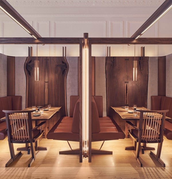 A stylish restaurant with cozy wood-paneled booths and sleek, modern lighting.