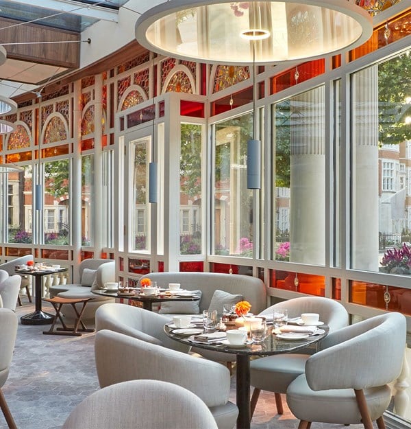 A bright, elegant dining area with stained glass windows and light-colored seating.