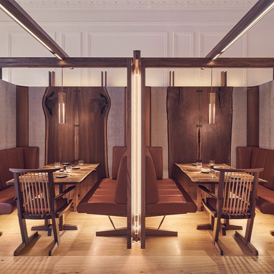 View of two tables with  a booth at the Connaught Grill, with wooden tables and wooden surroundings