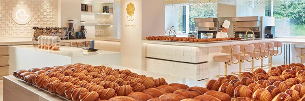 A bright, modern patisserie with neatly arranged croissants and light-colored interiors, offering a clean and inviting ambiance.