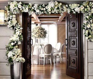 The sight of lavish flower arrangements adorning the entrance to the room where the wedding ceremony takes place.